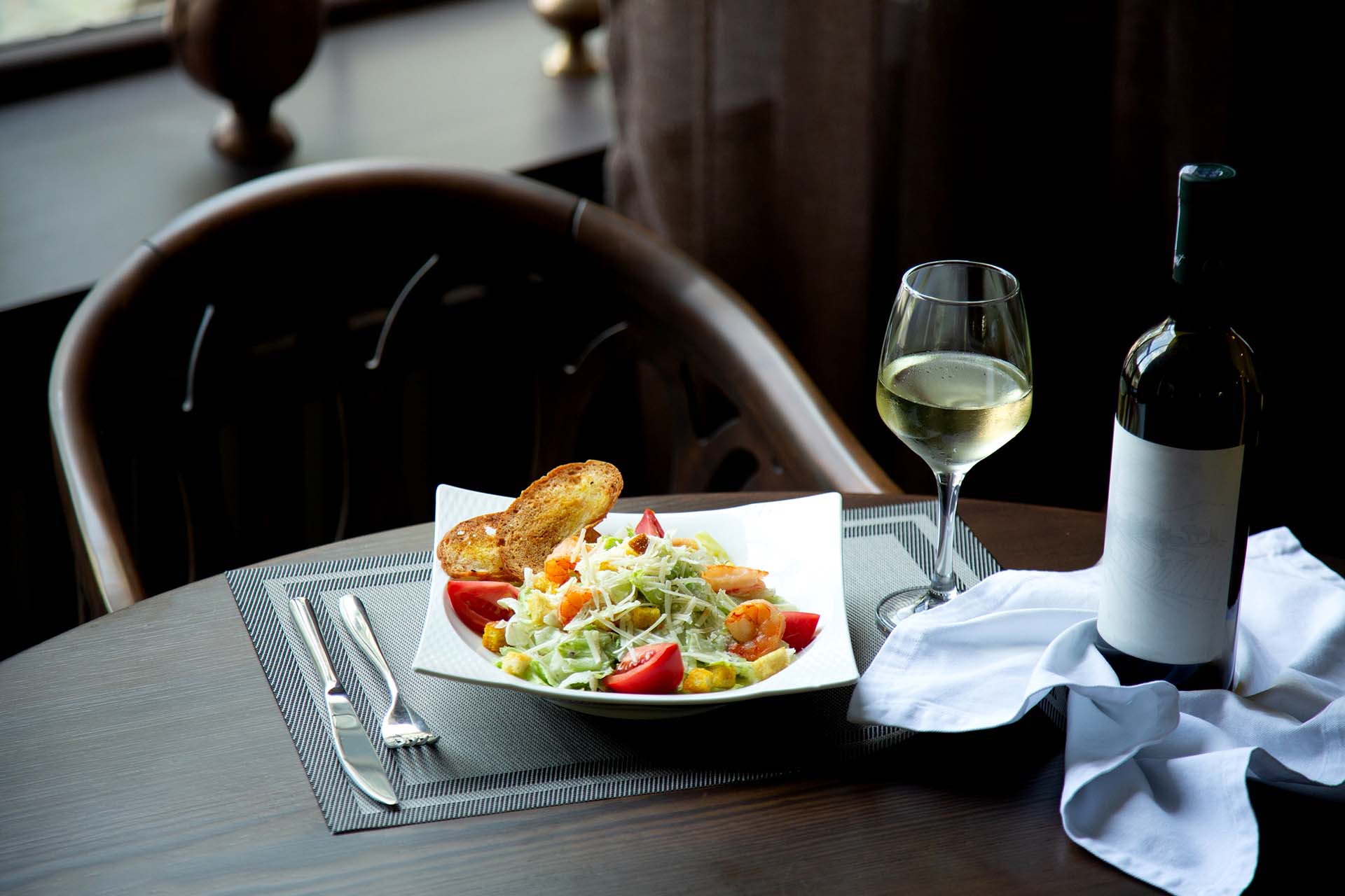 caesar salad with srimps and glass of white wine