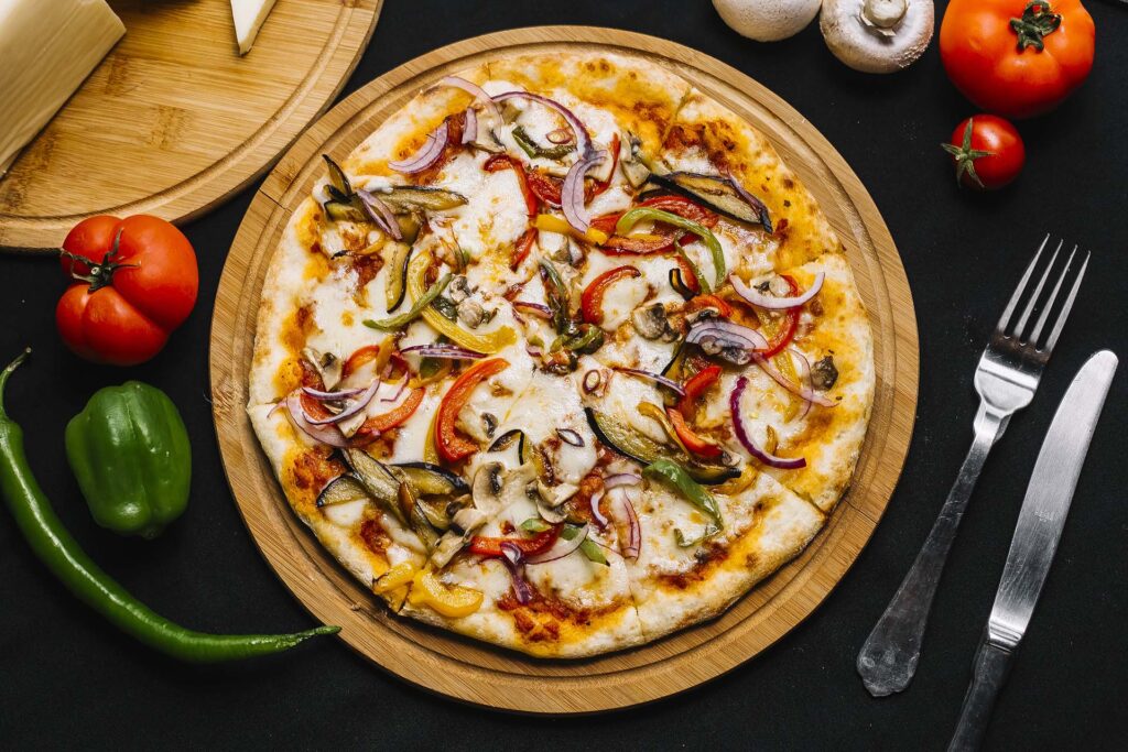 top view of vegetarian pizza with aubergine bell pepper red onion tomato and mushroom